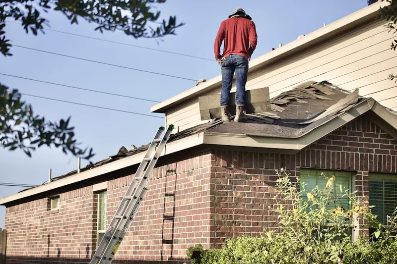 Professional roofer working on a residential roof in Old York Manor